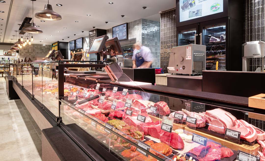 Fresh food counter for meat and sausage products, illuminated with Agira Plus recessed luminaire and Limba suspended luminaire. 